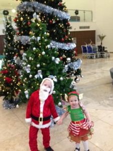 Two little children next to a Christmas tree