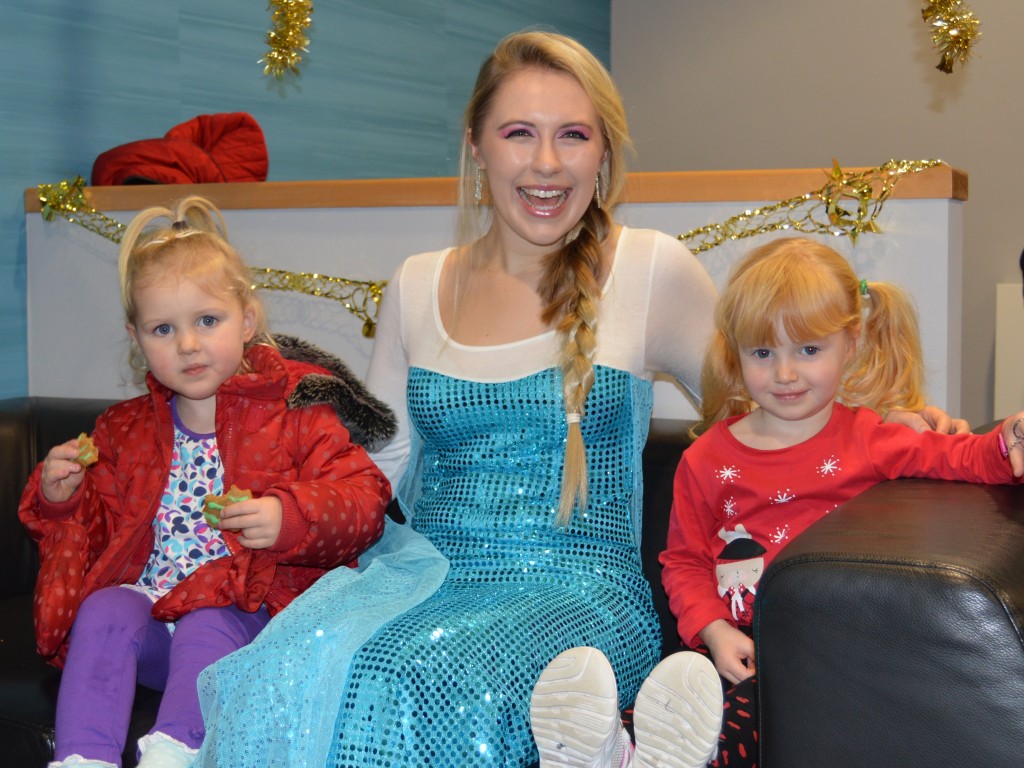 Woman dressed as Elsa from the film Frozen with two little girls