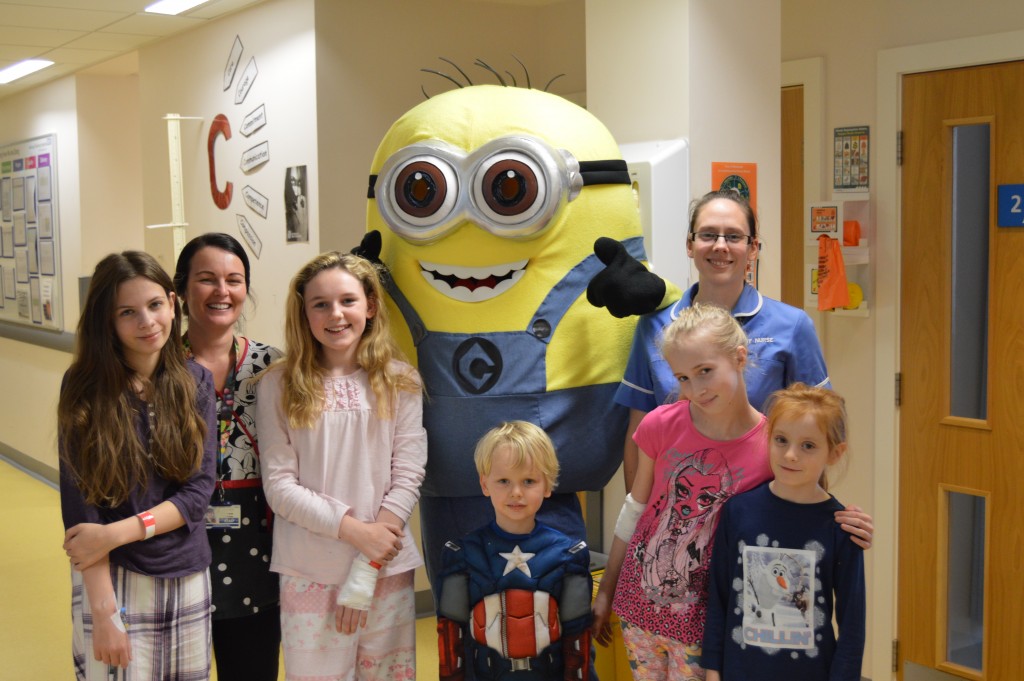 a group of young children with two nurses and the Minion character
