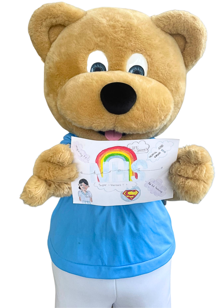 Blue Skies mascot bear holding up a picture drawn by a child
