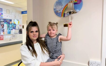 Bella Ellis with her mum ringing the treatment bell