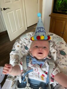 Baby Theodore Partington wearing a party hat