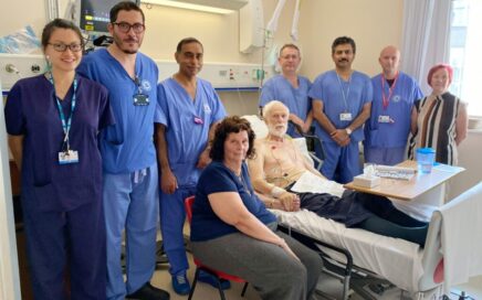 Group of surgeons and doctors with a patient who is in a hospital bed